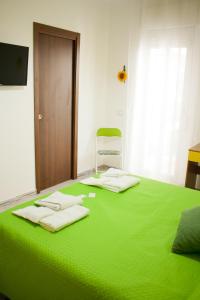ein Schlafzimmer mit einem grünen Bett und einem Stuhl in der Unterkunft B&B d'Orleans in Palermo