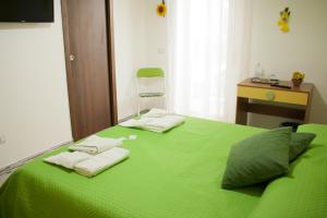 ein grünes Bett mit Handtüchern darüber in der Unterkunft B&B d'Orleans in Palermo