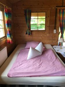 uma cama grande num quarto de madeira com janelas em Hof Keske em Peissen