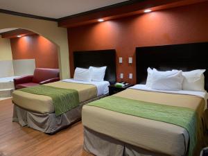 una habitación de hotel con 2 camas y una silla en Journey Inn Marion, en Marion