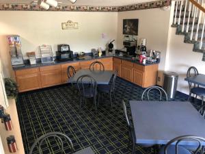 ein Restaurant mit Tischen und Stühlen in einem Zimmer in der Unterkunft Sunset Inn and Suites in Seward