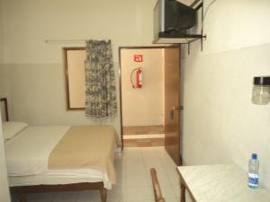a room with two beds and a door with a television at Hotel Kuraica in Ciudad Obregón