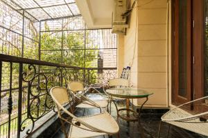 a balcony with chairs and a glass table at Hostie Aarna - 4BHK Independent Apartment at Kailash Colony, South Delhi in New Delhi