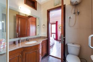 a bathroom with a sink and a toilet and a mirror at Hostie - 4BHK Apartment with lift near Greater Kailash, South Delhi in New Delhi +20 photos