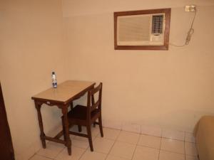 a table with a chair and a air conditioner in a room at Hotel Kuraica in Ciudad Obregón