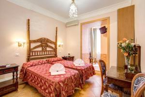 ローマにあるカラヴァッジョ ホテルのベッドとテーブルが備わるホテルルームです。