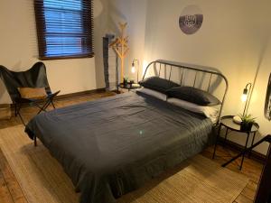 a bedroom with a bed and a chair and a window at Central Club Hotel in Melbourne