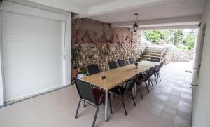 a dining room with a wooden table and chairs at Marivo Guest House in Molunat