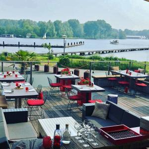 restauracja ze stołami i krzesłami oraz widokiem na wodę w obiekcie Motorjacht Flint w Amsterdamie