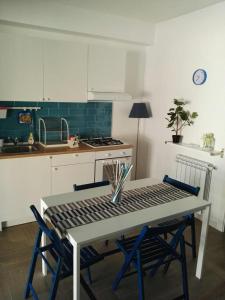 uma cozinha com uma mesa, 2 cadeiras e um fogão em Little house em Mazara del Vallo