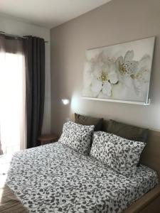 um quarto com uma cama com uma fotografia de flores na parede em Little house em Mazara del Vallo