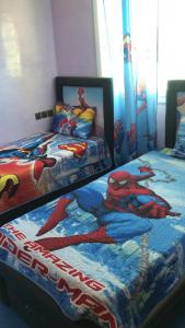 - une chambre avec 2 lits et un couvre-lit en araignée dans l'établissement Oum Khaltoum Martil, à Martil
