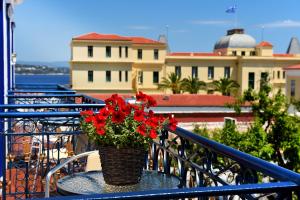 a vase with red flowers sitting on a table on a balcony at Armata Boutique Hotel in Spetses