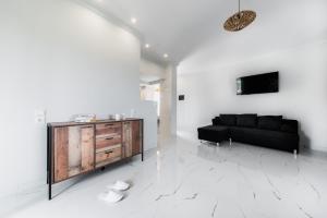 a living room with a black couch and a wooden cabinet at Zante Calinica Hotel in Tsilivi