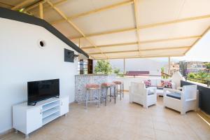 a living room with white furniture and a flat screen tv at Villa Sea Bella in Kalkan