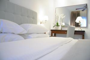 a bedroom with a bed and a desk with a mirror at Armata Boutique Hotel in Spetses
