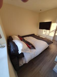 a bedroom with a bed with a television on the wall at Luxurious Luton town center flat with free parking in Luton