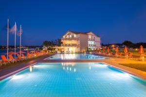 Una piscina frente a un hotel por la noche. en Al Mare Hotel, en Tsilivi