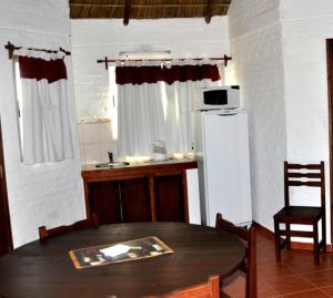 a room with a table and a kitchen with a refrigerator at Termas Sol Y Luna in Termas del Daymán