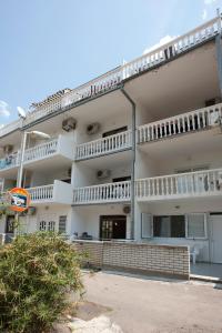 a large white building with balconies on top of it at Apartments Đurašević Ivo in Sveti Stefan