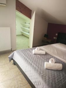 een slaapkamer met een bed met handdoeken erop bij Dimitra Boutique Apartments 1 in Keramotí