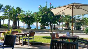 a patio with tables and chairs and an umbrella at La Sort Boutique Hotel in Moraira