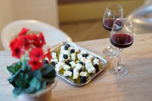 una mesa con una bandeja de comida y dos copas de vino en Apartmani Judita, en Zadar