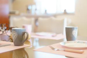 dos tazas de café y un plato en una mesa en Apartmani Judita en Zadar