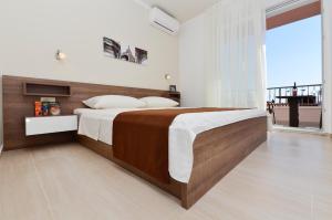 a bedroom with a large bed and a large window at Villa Cavar, Apartments Close to the Beach in Makarska