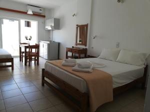una camera da letto con un letto con due asciugamani sopra di Karmi Apartments a Kolymvari Altre 35 foto