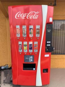 una máquina expendedora de coca cola frente a una tienda en Journey Inn Marion, en Marion