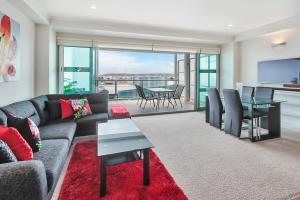 a living room with a couch and a table at QV Waterfront Magic Super Sunsets - 742 in Auckland