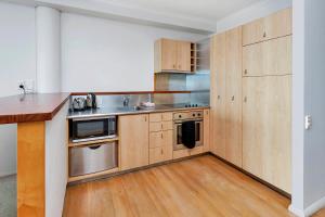 a kitchen with wooden cabinets and a counter top at QV Waterfront Magic Super Sunsets - 742 in Auckland