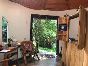 a room with a desk and a door with a window at Buddy's Hostel & Pousada Alto Paraiso in Alto Paraíso de Goiás