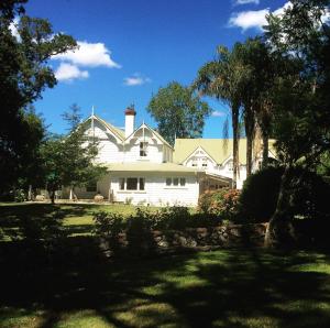 a white house with palm trees in front of it at Paheke Boutique Lodge in Kaikohe