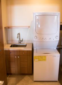 a small kitchen with a sink and a microwave at Quivira Los Cabos Condos and Homes -Vacation Rentals in Cabo San Lucas