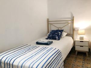 カラフェルにあるCasita de Pescadorのベッドルーム1室(青と白のストライプの毛布付きのベッド1台付)