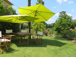 een tafel en stoelen met gele parasols in een tuin bij Casa de Encosturas in Cabeceiras de Basto