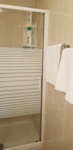 a shower with a glass door in a bathroom at Hostal Brunete in Brunete