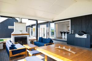 a living room with a table and a fireplace at Lawn Road Retreat in Clive