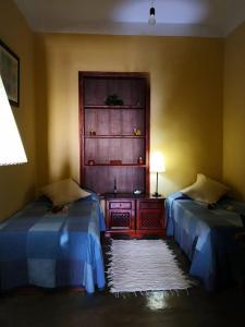 a room with two beds and a table with a lamp at Casa rural Los Órganos de Arguamul in Vallehermoso