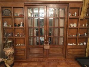 a large wooden cabinet with glass doors at Elites 1 in Alexandria