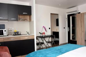 a kitchen and a bedroom with a bed and a table at Home Place Apartments - Langon Sauternes in Langon