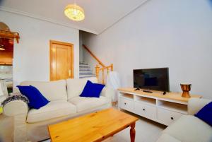 a living room with a white couch and a tv at 38 Fantastic Holiday // AC - WIFI in La Mata