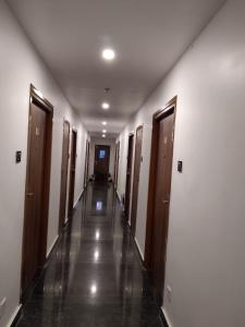 an empty hallway with wooden doors and a long corridor at Samsan Residentia in Visakhapatnam