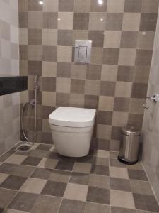 a bathroom with a toilet and a tiled floor at Samsan Residentia in Visakhapatnam