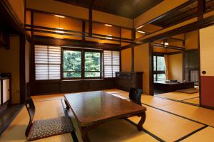 sala de estar con mesa de madera y sillas en Hazu Bekkan, en Ono