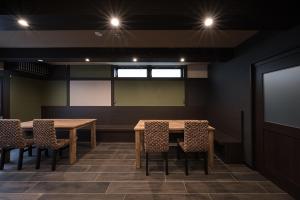 une salle de conférence avec deux tables et des chaises ainsi qu'un écran dans l'établissement Stay SAKURA Kyoto Matsuri, à Kyoto