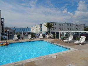 uma grande piscina com cadeiras e um edifício em Seabonay Oceanfront Motel em Ocean City