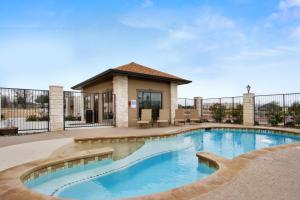 a swimming pool in front of a house at Microtel Inn & Suites by Wyndham Round Rock in Round Rock